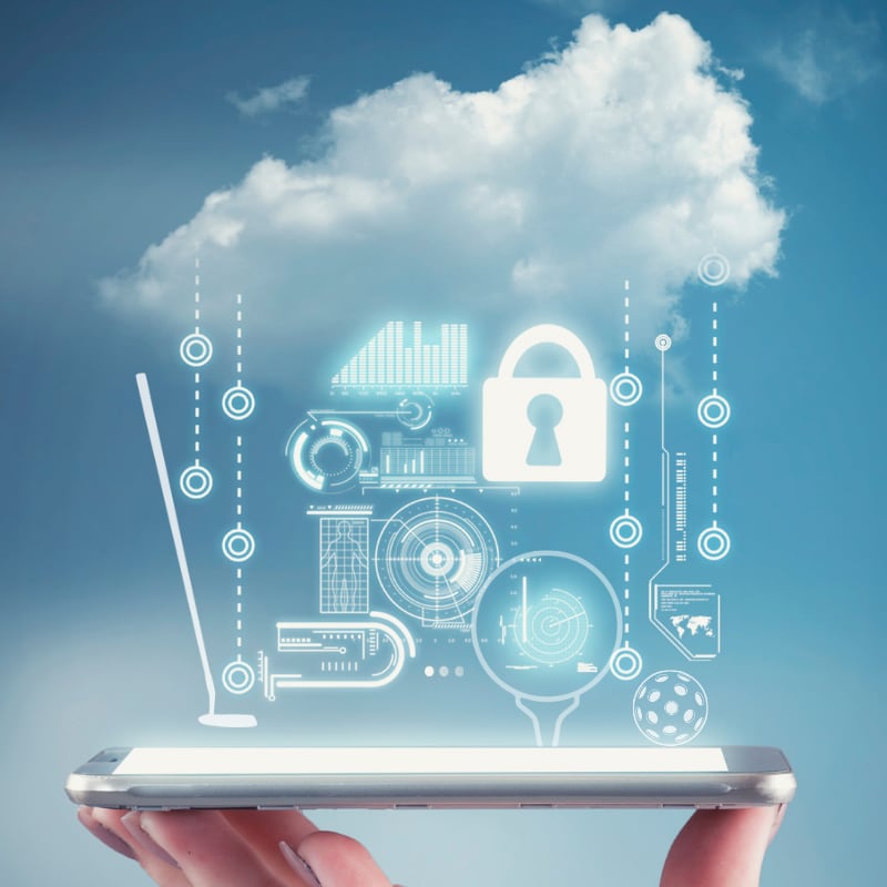 A hand holds a smartphone with digital cloud and security icons floating above it against a blue sky.