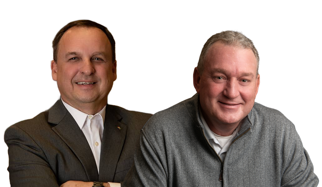 Two middle-aged men, one in a suit and the other in a gray sweater, smiling at the camera.